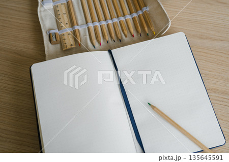 Open notebook with wooden pencil set and ruler on wooden desk surface Open notebook with wooden pencil set and ruler on wooden desk surface 135645591