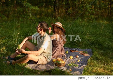 Duo sits peacefully on blanket amidst natural surroundings Duo sits peacefully on blanket amidst natural surroundings 135646012