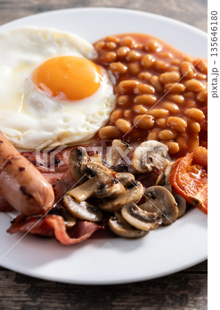 Full English breakfast with fried egg, bacon, sausages and beans Full English breakfast with fried egg, bacon, sausages and beans 135646180