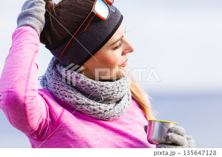 Fit woman in cold day warming up drink tea 135647128