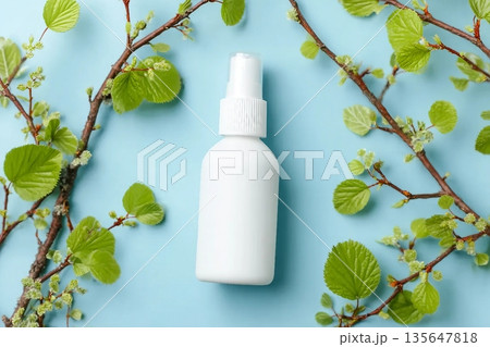 White cosmetic spray bottle and birch branches with young small leaves on blue background. Mockup branding. Skincare beauty and liquid antibacterial spray. Natural Body mist. Front view, flat lay. White cosmetic spray bottle and birch branches with young small leaves on blue background. Mockup branding. Skincare beauty and liquid antibacterial spray. Natural Body mist. Front view, flat lay. 135647818
