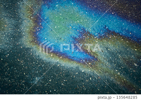 Diverse oil stain on the asphalt road, resulting in a captivating abstract pattern. 135648285