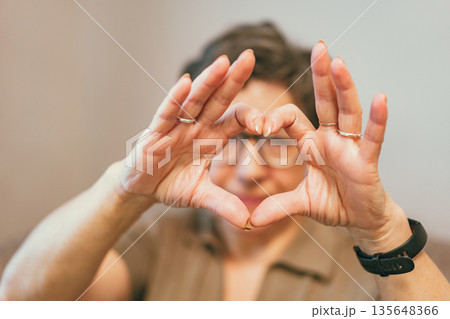 senior woman making a heart shape 135648366