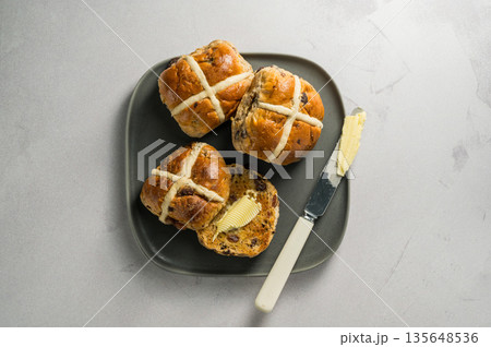 Cross Buns with butter in a plate. Breakfast concept. Top view. Easter treat buns Cross Buns with butter in a plate. Breakfast concept. Top view. Easter treat buns 135648536