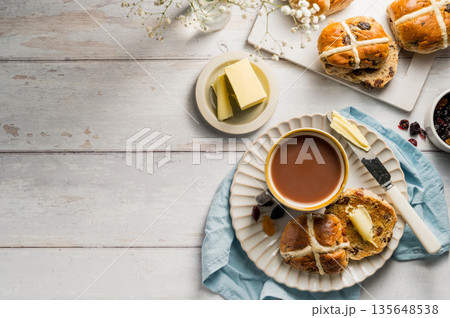 Cross Buns with butter in a plate. Breakfast concept. Top view. Easter treat buns with copy space Cross Buns with butter in a plate. Breakfast concept. Top view. Easter treat buns with copy space 135648538