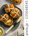 Cross Buns with butter in a plate. Breakfast concept. Top view. Easter treat buns 135648545