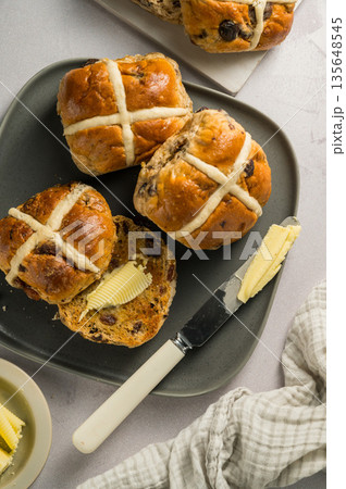 Cross Buns with butter in a plate. Breakfast concept. Top view. Easter treat buns Cross Buns with butter in a plate. Breakfast concept. Top view. Easter treat buns 135648545