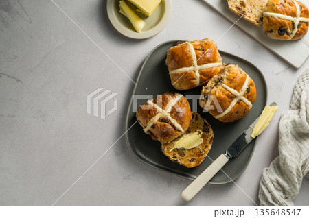 Cross Buns with butter in a plate. Breakfast concept. Top view with copy space. Easter treat buns Cross Buns with butter in a plate. Breakfast concept. Top view with copy space. Easter treat buns 135648547