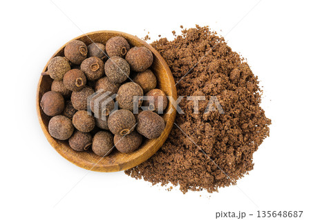 Allspice pepper and ground in wooden bowl isolated on white background. Jamaica pepper, Pimenta dioica or myrtle pepper. Top view Allspice pepper and ground in wooden bowl isolated on white background. Jamaica pepper, Pimenta dioica or myrtle pepper. Top view 135648687