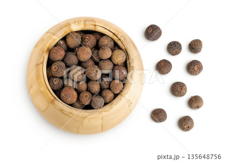 Allspice pepper in wooden bowl isolated on white background. Jamaica pepper, Pimenta dioica or myrtle pepper. Top view 135648756