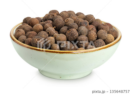 Allspice pepper in ceramic bowl isolated on white background. Jamaica pepper, Pimenta dioica or myrtle pepper. Allspice pepper in ceramic bowl isolated on white background. Jamaica pepper, Pimenta dioica or myrtle pepper. 135648757