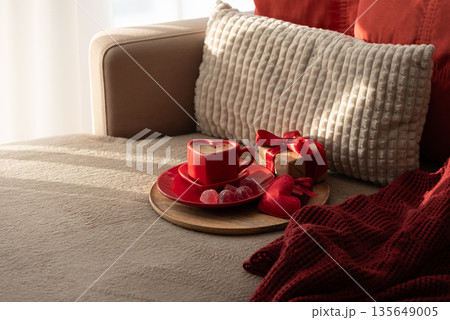 Heart Shaped Coffee Cup with Gift and Candies. Cozy Valentines Day Flatlay on Sofa 135649005