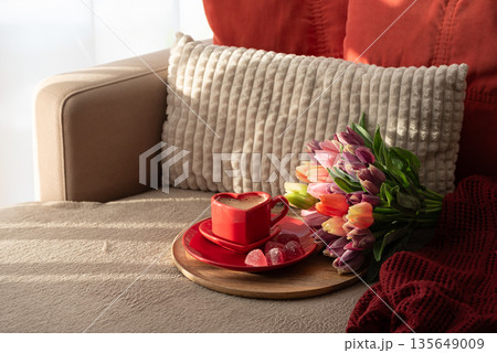 Heart Shaped Coffee Cup with Colorful Tulips and Candies. Cozy Romantic Flatlay on Sofa for Valentines Day Celebration Heart Shaped Coffee Cup with Colorful Tulips and Candies. Cozy Romantic Flatlay on Sofa for Valentines Day Celebration 135649009