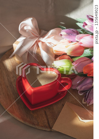 Heart Shaped Coffee Cup with Envelope and Tulips. Romantic Valentines Day Celebration Heart Shaped Coffee Cup with Envelope and Tulips. Romantic Valentines Day Celebration 135649023