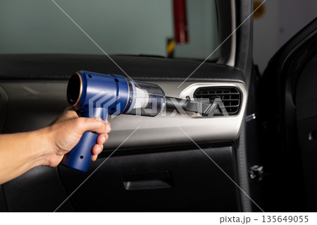 A person is cleaning the inside of a car with a vacuum A person is cleaning the inside of a car with a vacuum 135649055