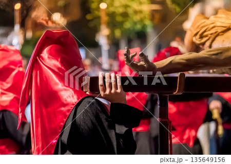 Close up of a penitent carrying a religious float Close up of a penitent carrying a religious float 135649156