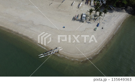 People beaching a double canoe on tropical beach in Brazil 135649363