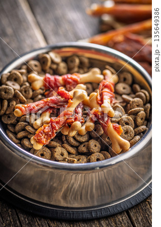 Dog food. Snack sticks for dogs and dry kibble food on wooden table. 135649386