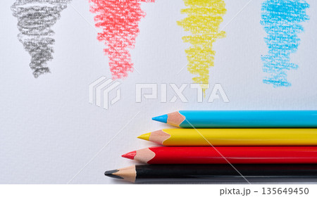 Four colored pencils lying on white paper, with a stroke of the corresponding color next to it Four colored pencils lying on white paper, with a stroke of the corresponding color next to it 135649450