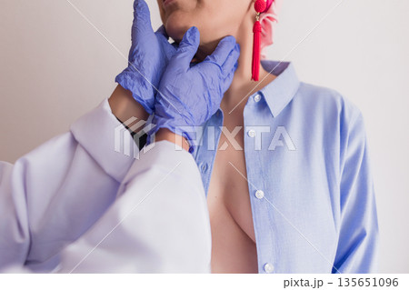 Doctor examining female patient's neck, checking thyroid gland Doctor examining female patient's neck, checking thyroid gland 135651096