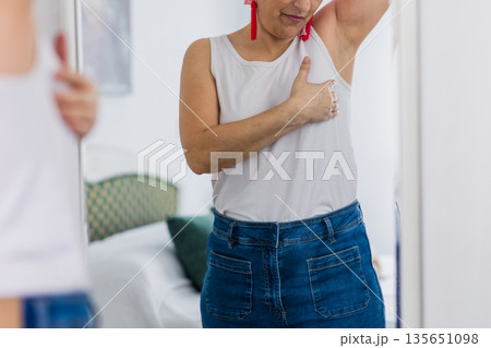 Woman performing breast self examination for cancer prevention Woman performing breast self examination for cancer prevention 135651098