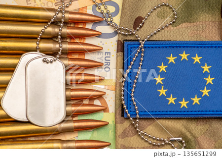 Army identification tags and ammunition on euro banknotes with European Union patch. 135651299