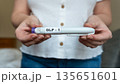 GLP-1 injection pen held by woman in front of abdomen, weight management concept 135651601