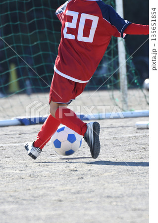 ドリブルするサッカー選手 135651854