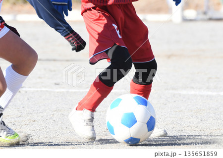 ドリブルするサッカー選手 135651859