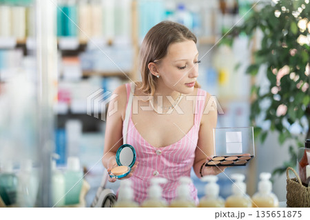Woman in a dress choosing cosmetics in pharmacy 135651875