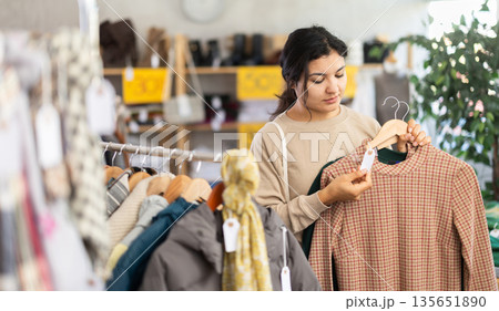 Latina chooses a warm dress in the store Latina chooses a warm dress in the store 135651890