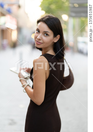 Stylish young woman walking with phone on Barcelona street 135651987