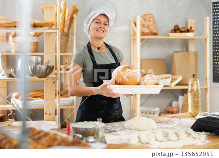 Woman seller holding basket with homemade bread in bakery 135652051