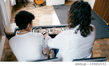 Music teacher guiding young student learning piano keyboard Music teacher guiding young student learning piano keyboard 135652153