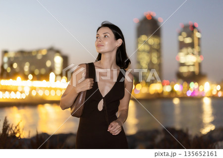 Young woman standing at seaside against background of twin towers 135652161