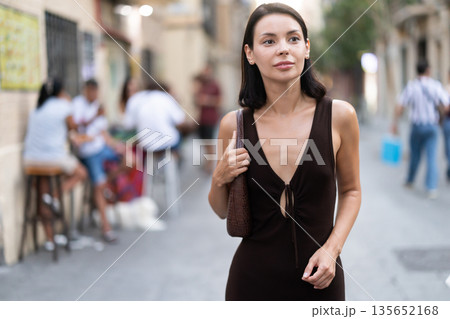 Young woman walks along narrow street in old Barcelona Young woman walks along narrow street in old Barcelona 135652168