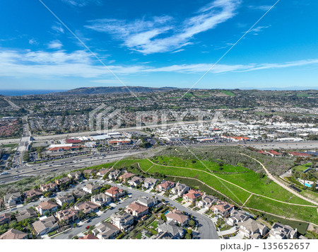 Aerial view over San Juan Capistrano, California, featuring the historic mission, library, sports courts, and an Amtrak train pulling into the downtown station. Aerial view over San Juan Capistrano, California, featuring the historic mission, library, sports courts, and an Amtrak train pulling into the downtown station. 135652657