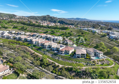 Aerial view over San Juan Capistrano, California, featuring the historic mission, library, sports courts, and an Amtrak train pulling into the downtown station. Aerial view over San Juan Capistrano, California, featuring the historic mission, library, sports courts, and an Amtrak train pulling into the downtown station. 135652658