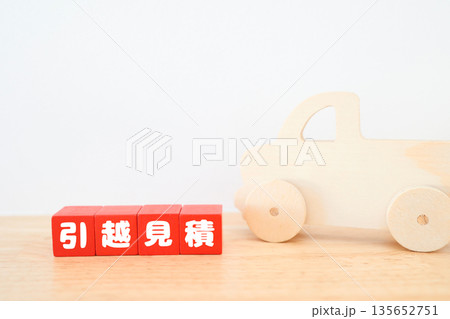 引越し見積もりを表す赤い木製ブロックとトラックのおもちゃ。 引越し見積もりを表す赤い木製ブロックとトラックのおもちゃ。 135652751