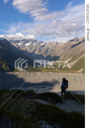 Hiker overlooking glacial Hooker Lake and Mount Cook, New Zealand 135652916