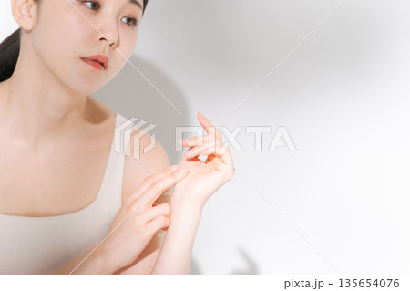 頬に手を当てる若い女性 135654076