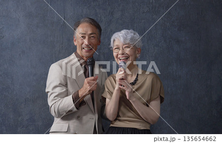 カラオケをするシニアの男性と女性　黒背景　ポートレート　カメラ目線 135654662