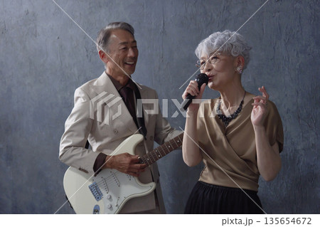 シニアのミュージシャン 男性のギタリストと女性のボーカル 黒背景 シニアのミュージシャン 男性のギタリストと女性のボーカル 黒背景 135654672