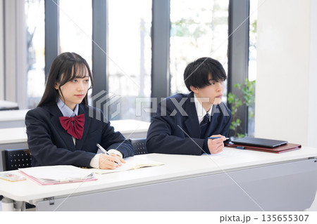 学校や塾、予備校にノートを取る高校生の男女が前向きに授業へ取り組む教室の風景　大学受験などのイメージ 135655307