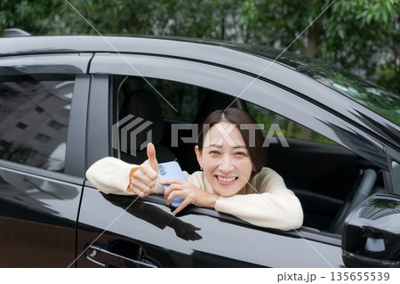 車のドアから顔を出す女性 135655539