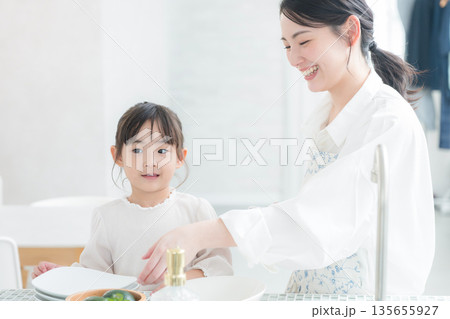 キッチンで料理やお皿を洗う親子　おままごとのようにママのお手伝いをする	 135655927