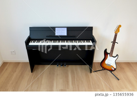 リビングに置かれたエレキギターと電子ピアノ「譜面台にタブレット端末」 135655936
