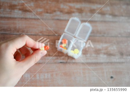 左手でカプセルをつまむ 135655990