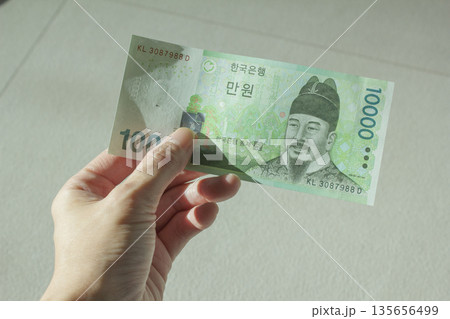 A woman's hand holding ten thousand won 135656499