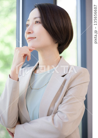 窓際で考えるビジネスマンの女性 キャリアに悩む転職どうしようかな 窓際で考えるビジネスマンの女性 キャリアに悩む転職どうしようかな 135656687